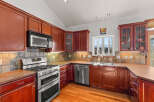 This stunning kitchen boasts rich, wooden cabinetry and sleek stainless steel appliances, creating a warm and inviting atmosphere.