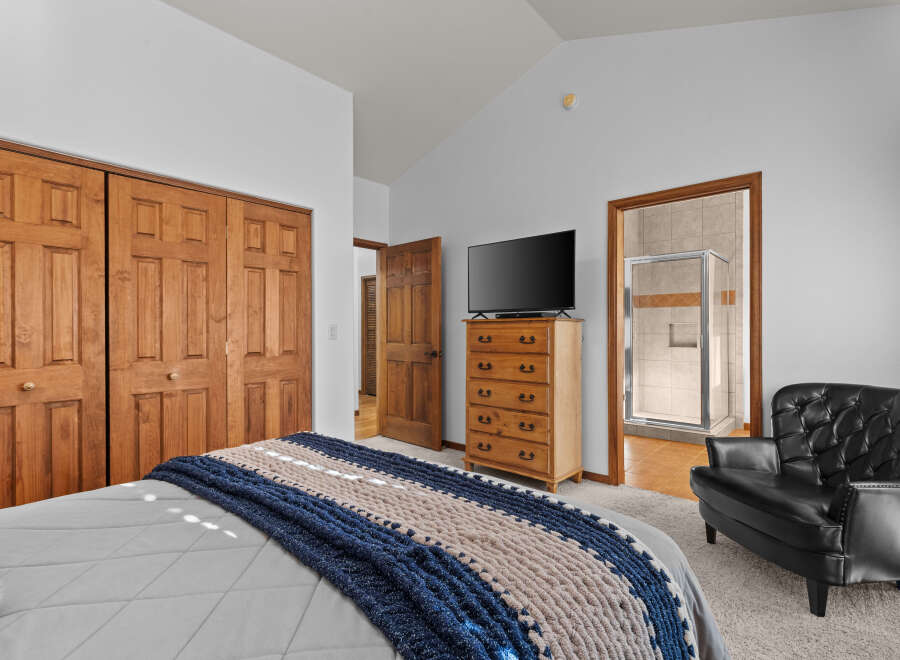 This inviting bedroom features a cozy bed adorned with a stylish blue and beige throw blanket.