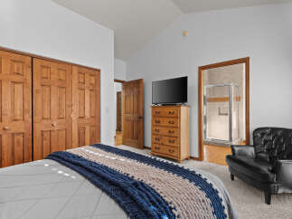 This inviting bedroom features a cozy bed adorned with a stylish blue and beige throw blanket.