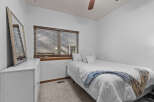 This cozy bedroom features a comfortable bed with a stylish blue and white blanket, perfect for a relaxing night's sleep.