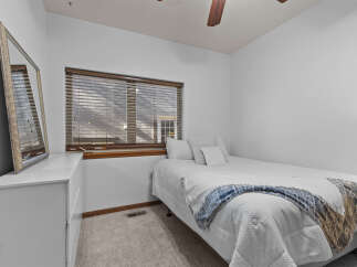 This cozy bedroom features a comfortable bed with a stylish blue and white blanket, perfect for a relaxing night's sleep.