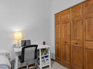 This cozy room features a functional workspace with a desk, chair, and a laptop, perfect for work or study.
