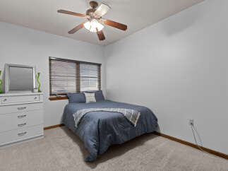 This cozy bedroom features a comfortable bed with a stylish blue comforter and a decorative throw blanket.
