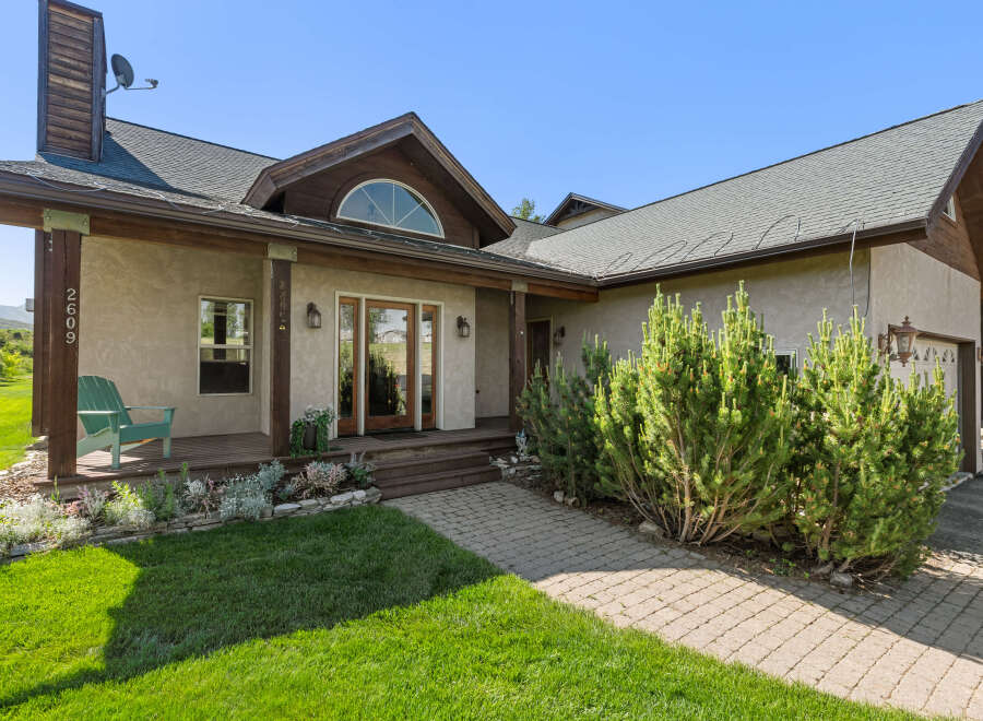 This stunning property boasts a charming exterior with a welcoming porch and lush landscaping.