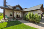 This stunning property boasts a charming exterior with a welcoming porch and lush landscaping.