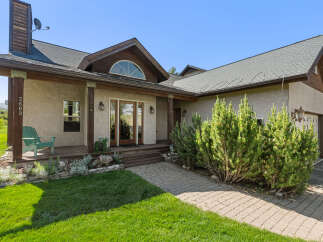This stunning property boasts a charming exterior with a welcoming porch and lush landscaping.