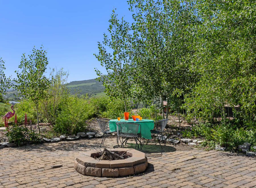 Enjoy outdoor living at its finest with this charming property! Featuring a cozy fire pit, perfect for gatherings, and a shaded dining area, this space is ideal for relaxation and entertainment.