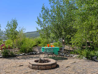 Enjoy outdoor living at its finest with this charming property! Featuring a cozy fire pit, perfect for gatherings, and a shaded dining area, this space is ideal for relaxation and entertainment.