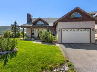 This stunning property boasts a beautiful exterior with a well-manicured lawn and lush landscaping.