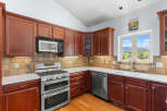 This stunning kitchen boasts rich, dark wood cabinetry and a modern stainless steel appliance package.