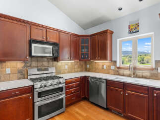 This stunning kitchen boasts rich, dark wood cabinetry and a modern stainless steel appliance package.
