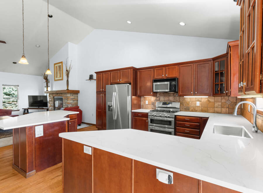 This stunning kitchen boasts a modern design with sleek countertops and rich wood cabinetry.