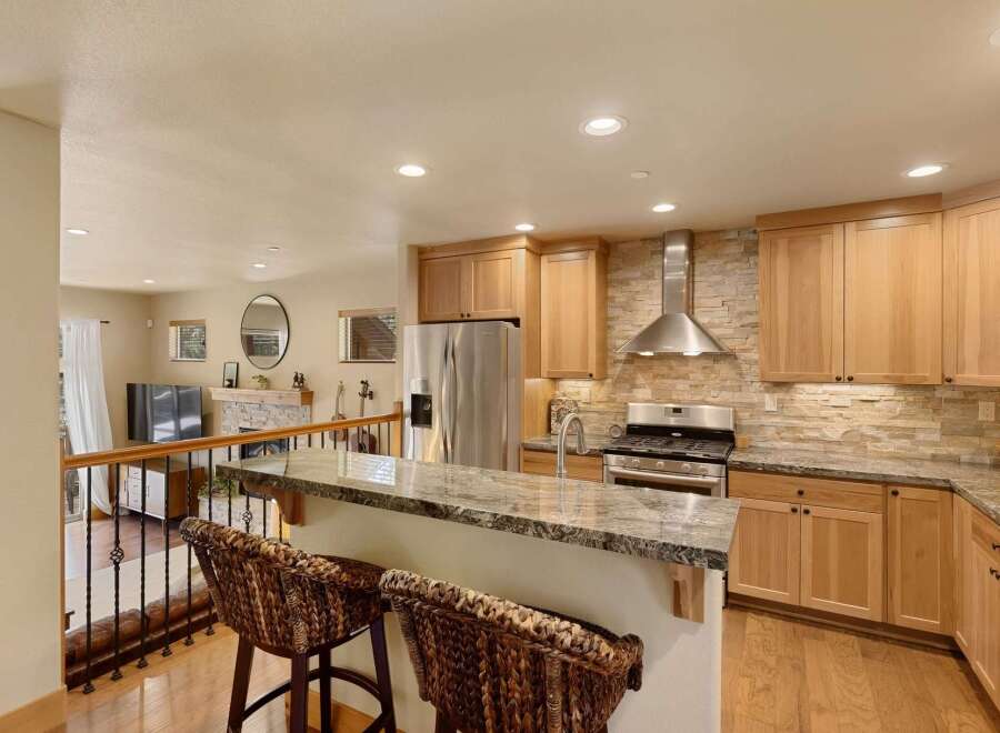 This stunning kitchen boasts a modern design with a beautiful stone backsplash and stainless steel appliances.
