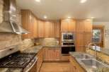 This stunning kitchen boasts custom cabinetry, stainless steel appliances, and a beautiful stone backsplash.