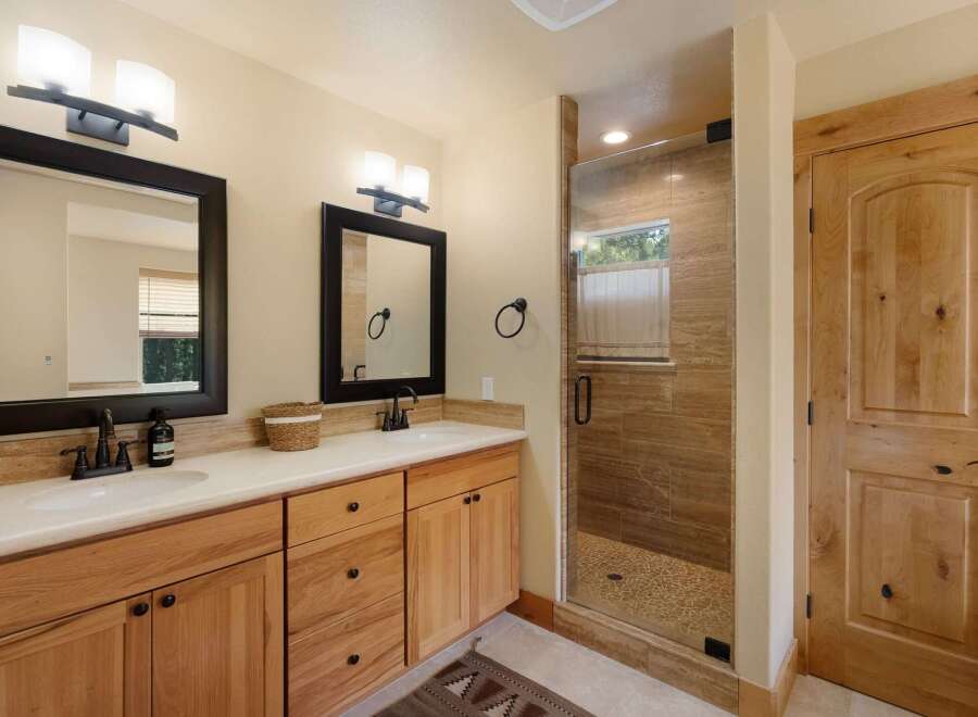 This stunning bathroom features a modern design with natural wood cabinetry and sleek black fixtures.