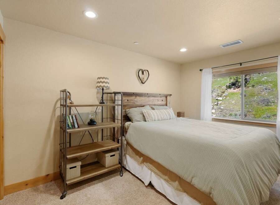 This cozy bedroom features a rustic wooden headboard and a charming heart-shaped wall decor, creating a warm and inviting atmosphere.
