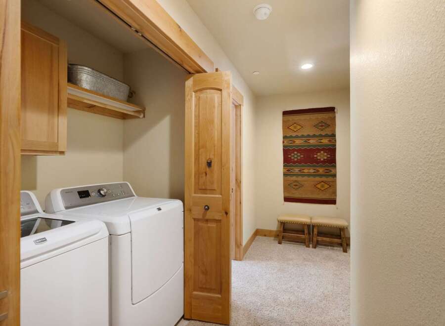 Step into this beautifully designed laundry room, featuring modern appliances and ample storage.