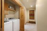 Step into this beautifully designed laundry room, featuring modern appliances and ample storage.