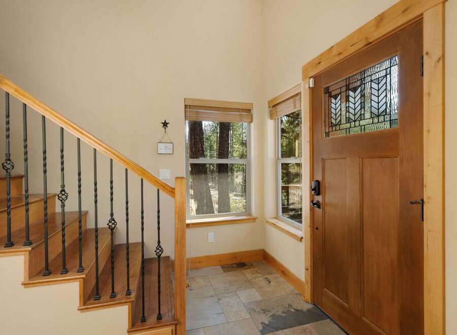 Step into this inviting entryway, showcasing a beautiful wooden door with intricate glass detailing.