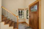 Step into this inviting entryway, showcasing a beautiful wooden door with intricate glass detailing.