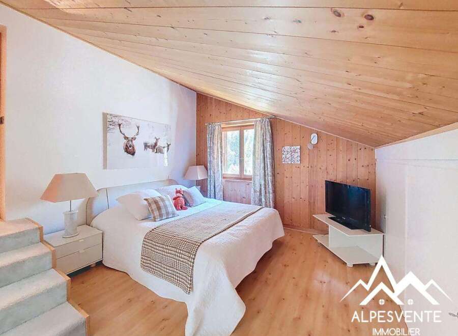 This charming bedroom features a cozy wooden ceiling and walls, creating a warm and inviting atmosphere.