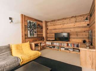 This cozy living space features a stunning wooden accent wall, creating a warm and inviting atmosphere.