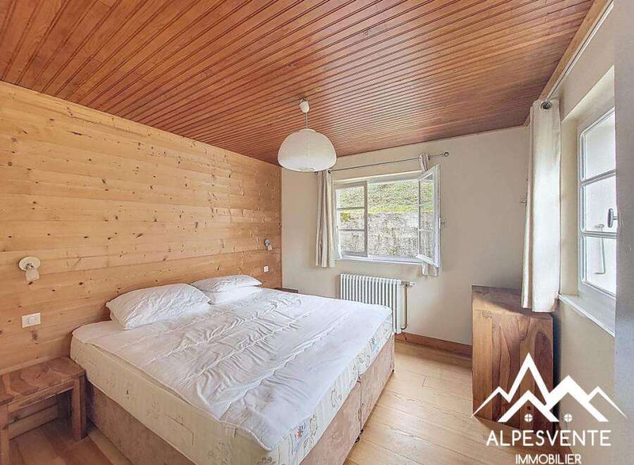 Discover the charm of this cozy bedroom featuring a warm wooden ceiling and walls, creating a rustic and inviting atmosphere.