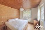 Discover the charm of this cozy bedroom featuring a warm wooden ceiling and walls, creating a rustic and inviting atmosphere.