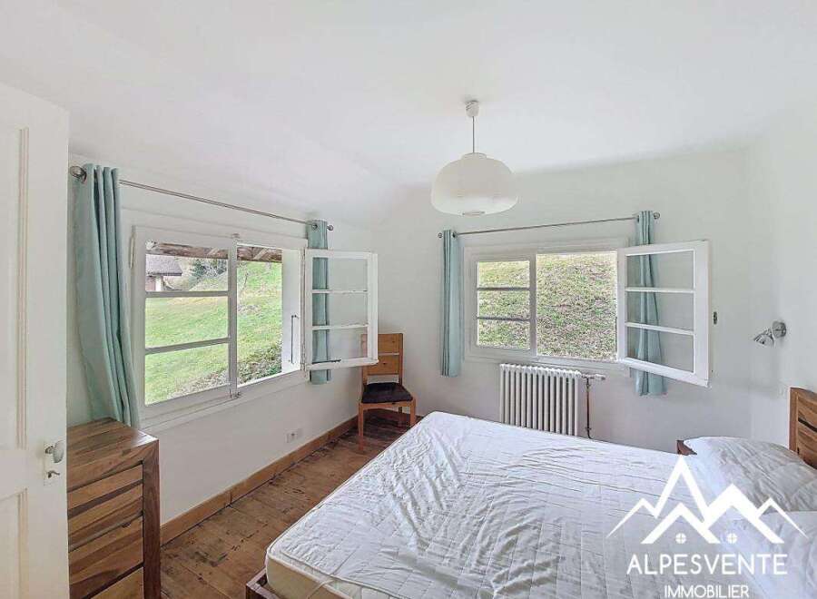 Discover the charm of this inviting bedroom, featuring bright windows that offer stunning views of the surrounding landscape.