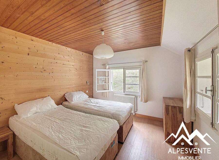 This charming bedroom features a cozy wooden ceiling and walls, creating a warm and inviting atmosphere.
