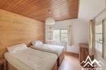 This charming bedroom features a cozy wooden ceiling and walls, creating a warm and inviting atmosphere.