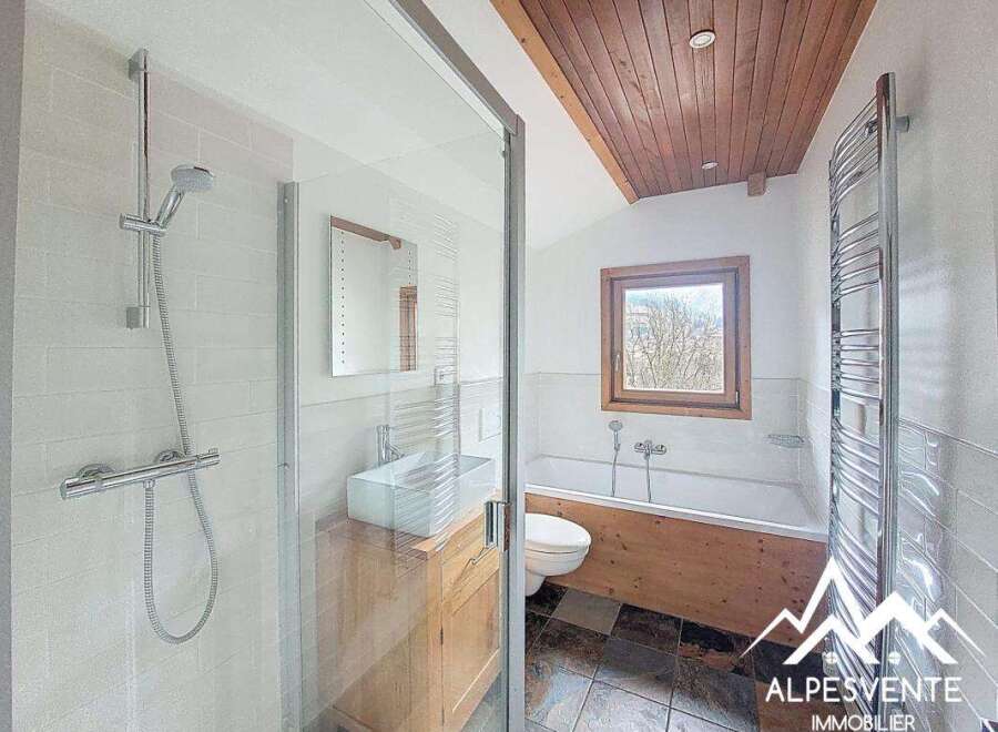 Discover this charming bathroom featuring a modern shower and a relaxing bathtub.