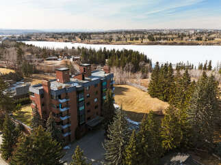 Discover luxury living in this stunning condo with breathtaking views of the frozen lake and surrounding nature.