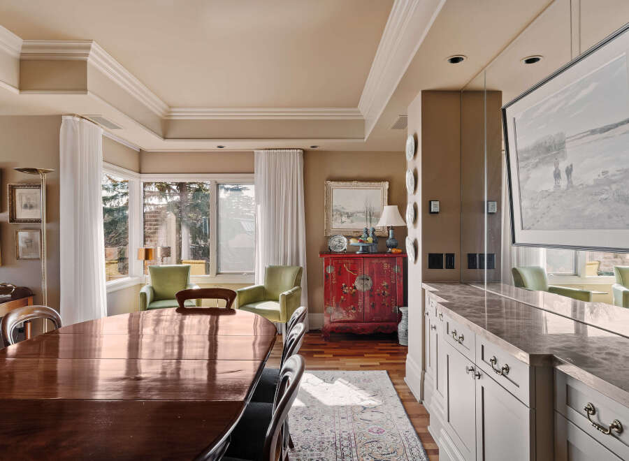 Step into luxury with this stunning dining room, featuring a beautiful wooden table and elegant chairs.