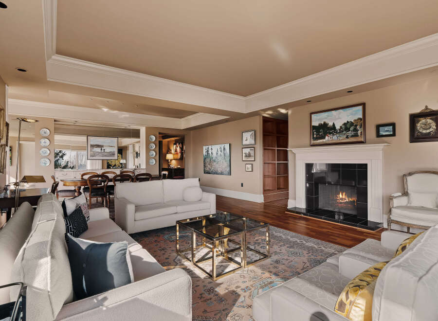Step into luxury with this stunning living room, featuring a cozy fireplace and elegant white sofas.
