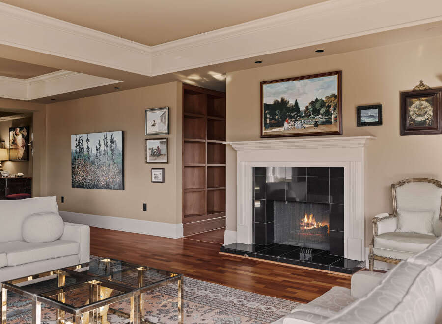 Step into luxury with this stunning living room, featuring a cozy fireplace and elegant hardwood floors.