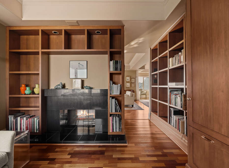This stunning property boasts a custom built-in bookshelf and fireplace, perfect for cozy evenings.
