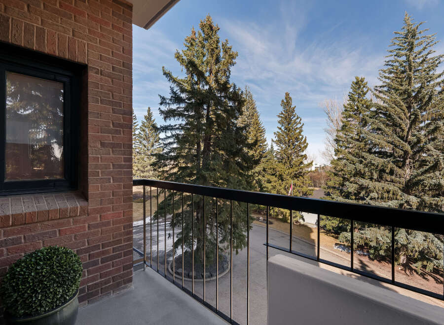 Enjoy breathtaking views from this stunning balcony! This property features a beautiful brick exterior and a lush green plant, creating a serene atmosphere.