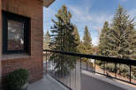 Enjoy breathtaking views from this stunning balcony! This property features a beautiful brick exterior and a lush green plant, creating a serene atmosphere.