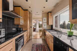 This stunning kitchen boasts sleek black countertops and modern appliances, creating a sophisticated cooking space.