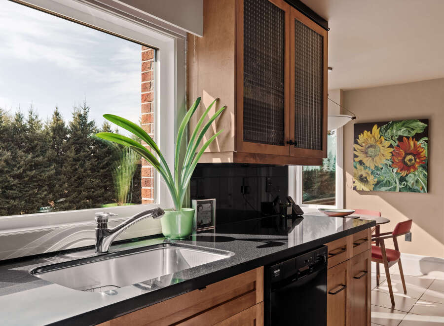 This stunning kitchen boasts a modern design with sleek black countertops and warm wooden cabinetry.