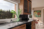 This stunning kitchen boasts a modern design with sleek black countertops and warm wooden cabinetry.