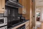 This stunning kitchen boasts sleek black countertops and modern appliances, perfect for culinary enthusiasts.