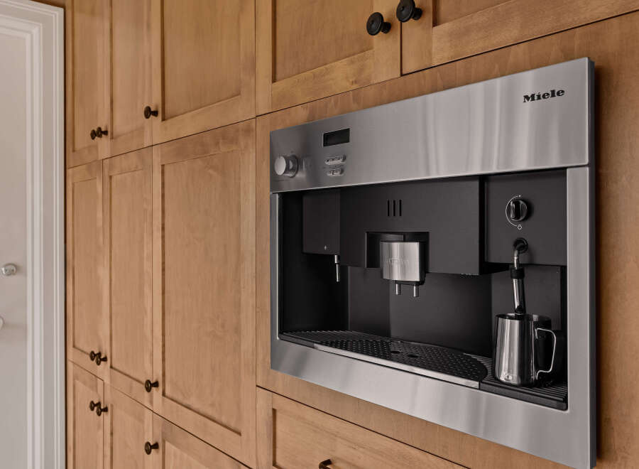 This stunning kitchen boasts custom cabinetry and a built-in Miele coffee maker, perfect for the discerning homeowner.