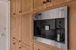 This stunning kitchen boasts custom cabinetry and a built-in Miele coffee maker, perfect for the discerning homeowner.