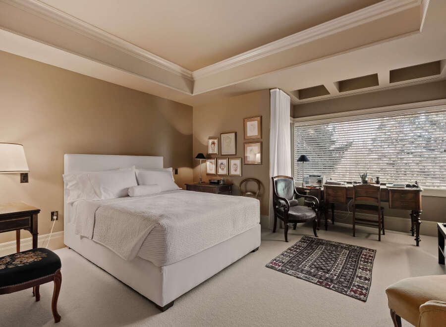 This elegant bedroom offers a serene retreat with its neutral color palette and sophisticated design.