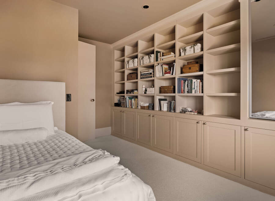 This bedroom boasts a custom built-in bookcase, providing ample storage and a touch of elegance.