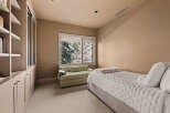 This elegant bedroom offers a serene retreat with its neutral color palette and ample natural light.