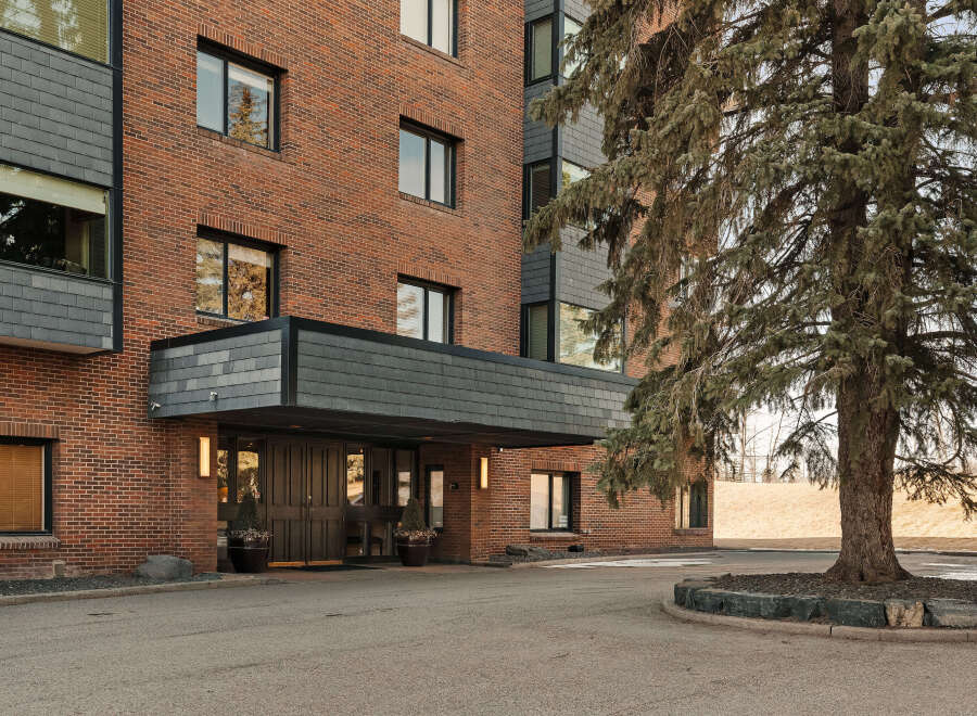 This stunning brick building offers a welcoming entrance with a covered entryway, perfect for residents and guests.
