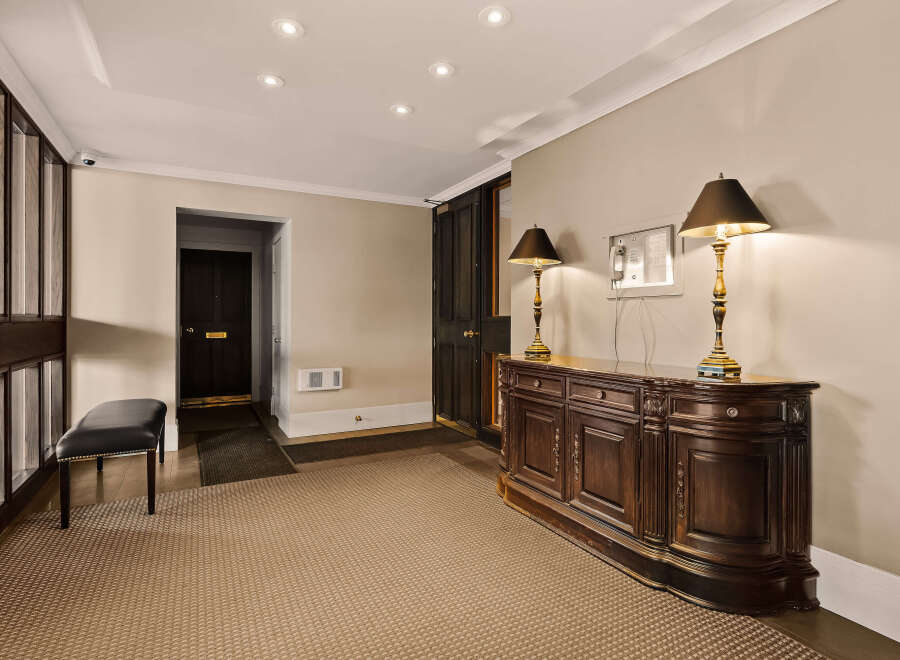 Step into luxury with this stunning entryway, featuring a beautifully crafted wooden console table and elegant lamps.
